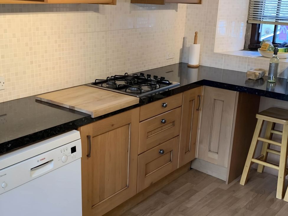A kitchen with a gas stove and cutting board at Stunning cottage - 3 Bedrooms & 3 Bathrooms