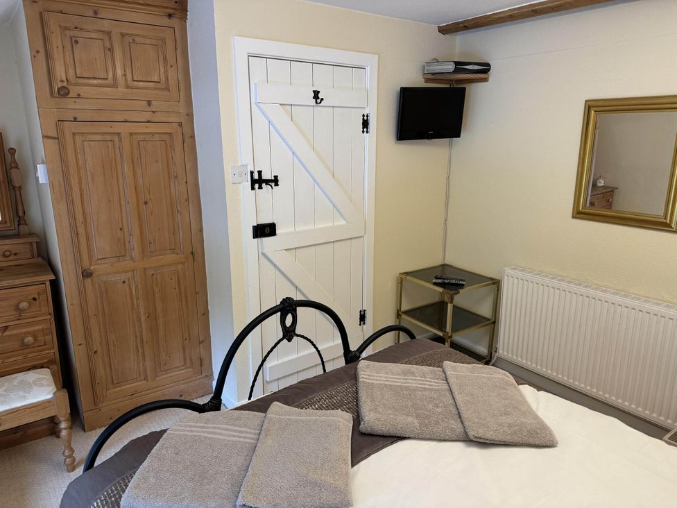 A bedroom with a bed, dresser, and a television at Stunning cottage - 3 Bedrooms & 3 Bathrooms