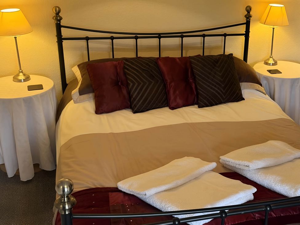 A bedroom with a bed and bedside tables at Stunning cottage - 3 Bedrooms & 3 Bathrooms