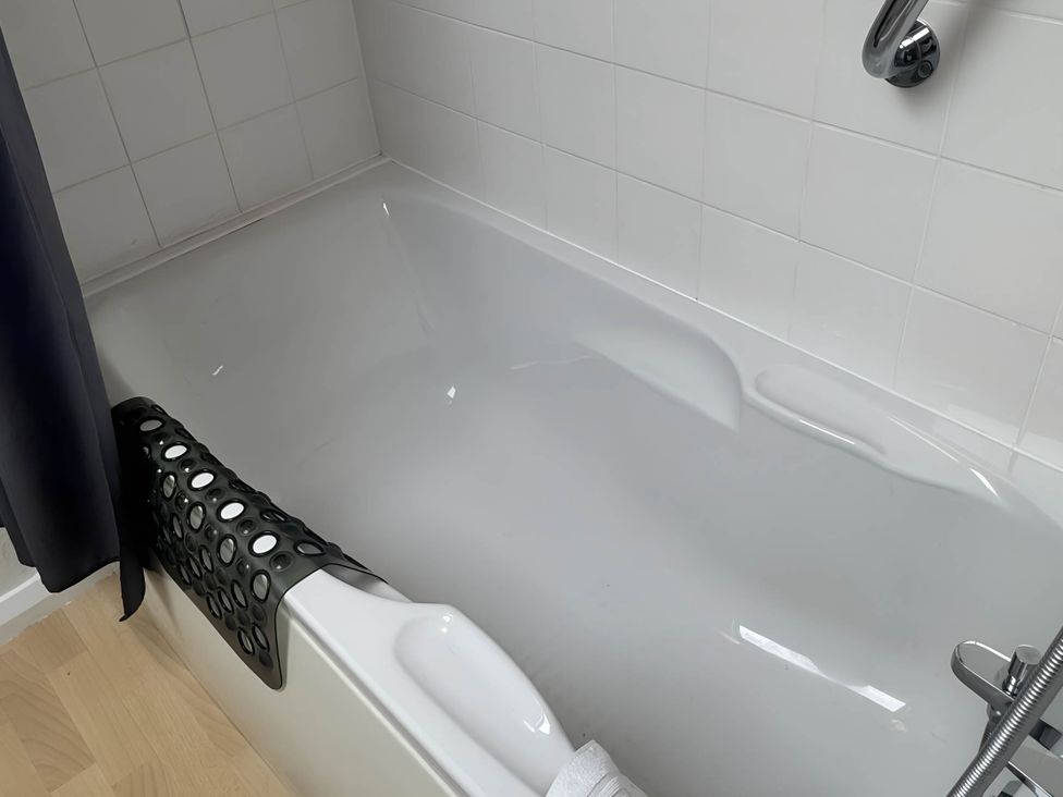A bathtub with a black bath mat and a faucet at Stunning cottage - 3 Bedrooms & 3 Bathrooms
