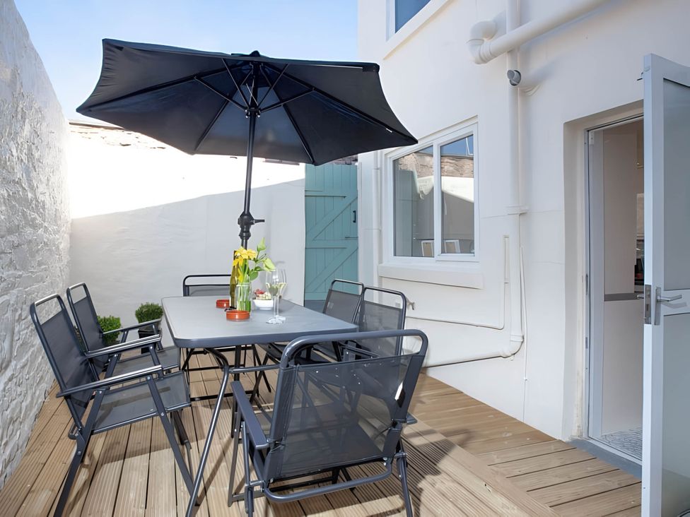 An outdoor patio with a table and chairs at Torquay - House - Sleeps 6 - Pet Friendly