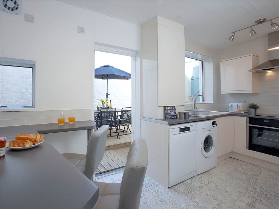 A kitchen with washing machine and table at Torquay - House - Sleeps 6 - Pet Friendly