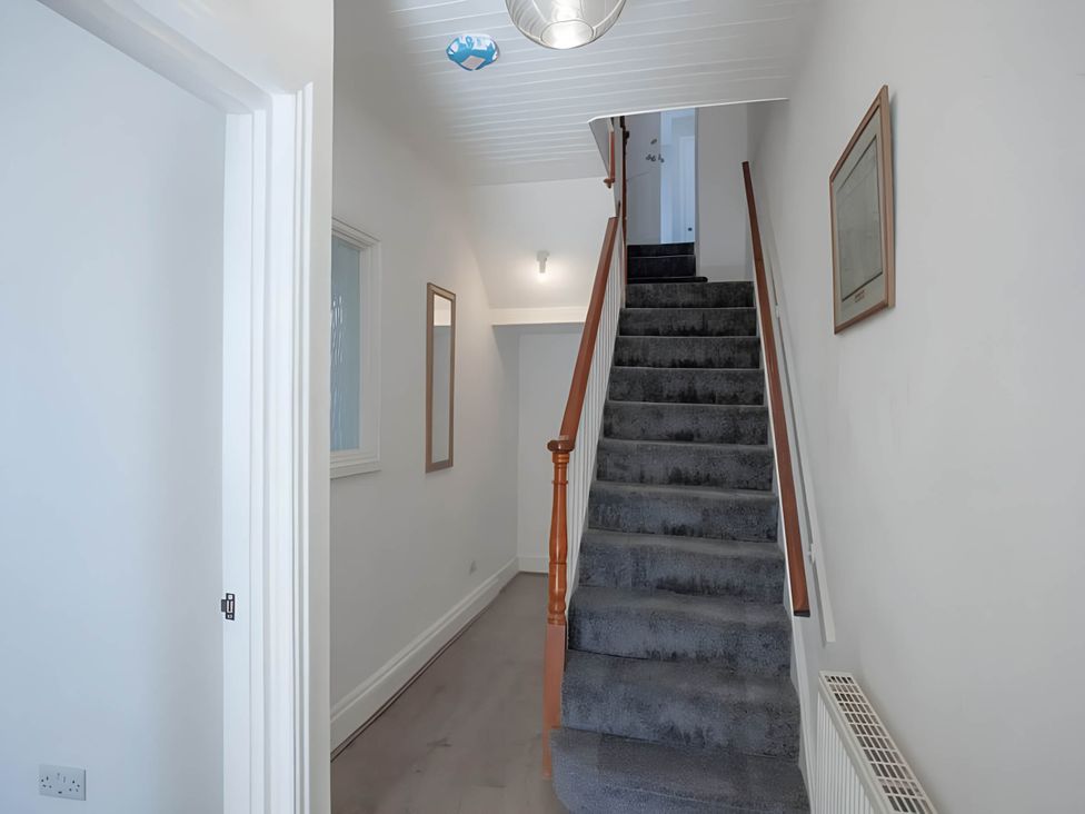 A hallway with stairs and mirrors at Torquay - House - Sleeps 6 - Pet Friendly