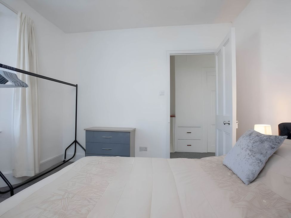 A bedroom with a bed, wardrobe and lamp at Torquay - House - Sleeps 6 - Pet Friendly