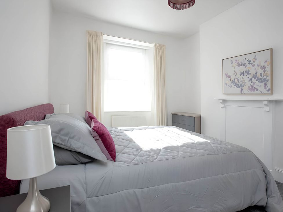 A bedroom with a bed and lamp at Torquay - House - Sleeps 6 - Pet Friendly