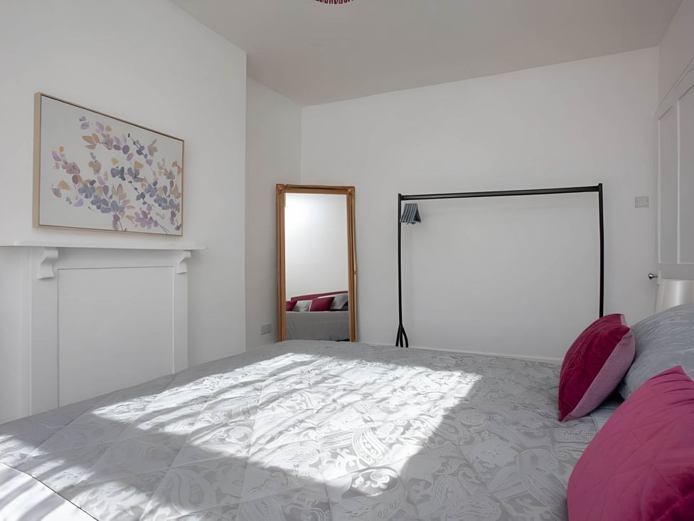 A bedroom with a bed and a mirror at Torquay - House - Sleeps 6 - Pet Friendly