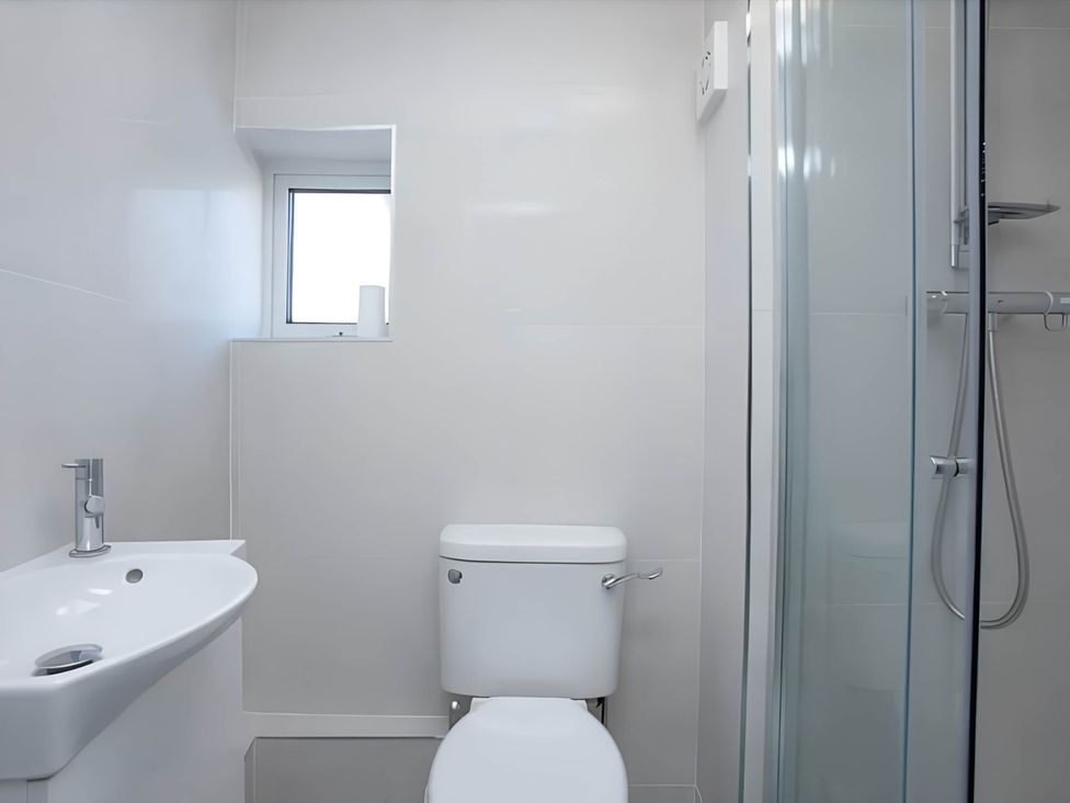 A bathroom with a sink, toilet, and shower at Torquay - House - Sleeps 6 - Pet Friendly