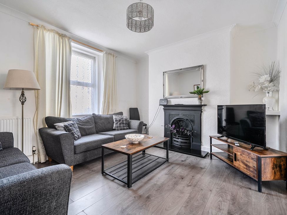A living room with a sofa, coffee table, television, and fireplace at Torquay - House - Sleeps 6 - Pet Friendly, Torquay