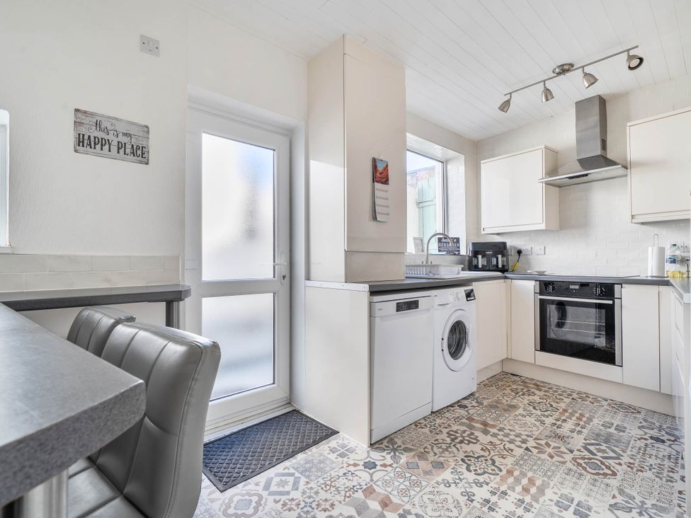 A kitchen with appliances and seating at Torquay - House - Sleeps 6 - Pet Friendly, Torquay