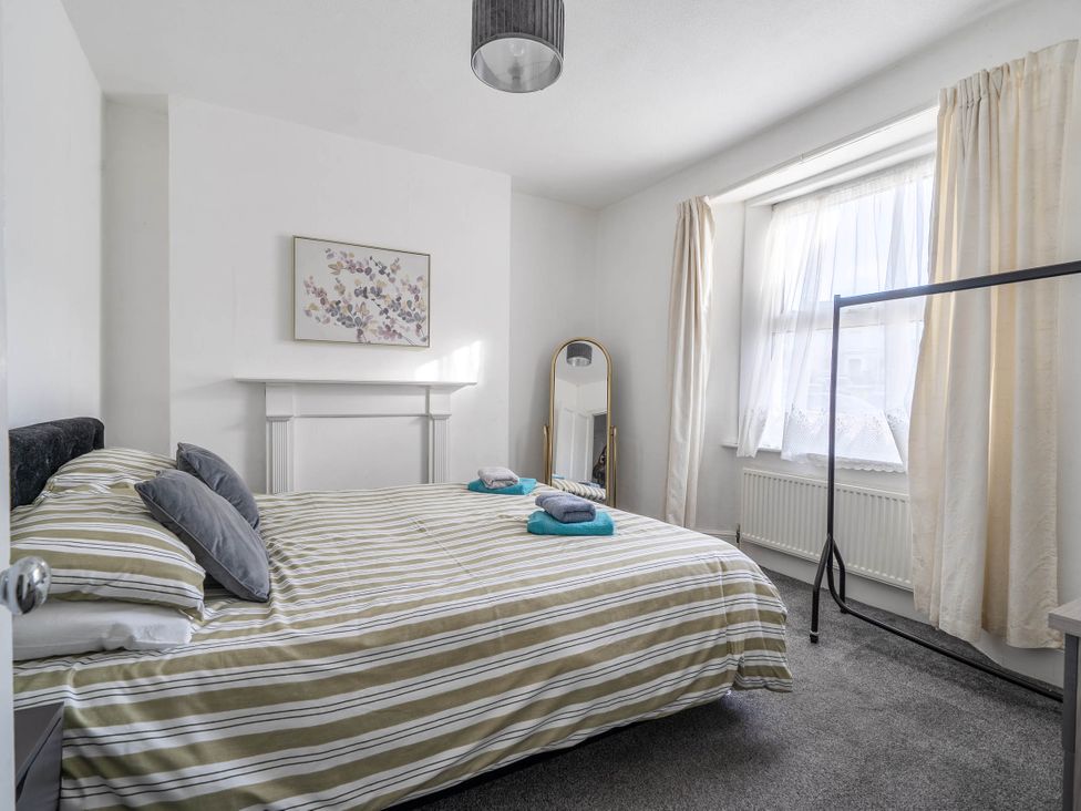 A bedroom with a bed and mirror at Torquay - House - Sleeps 6 - Pet Friendly, Torquay