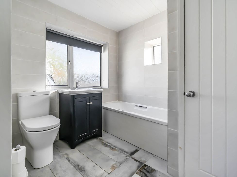 A bathroom with a toilet, sink, and bathtub at Torquay - House - Sleeps 6 - Pet Friendly, Torquay