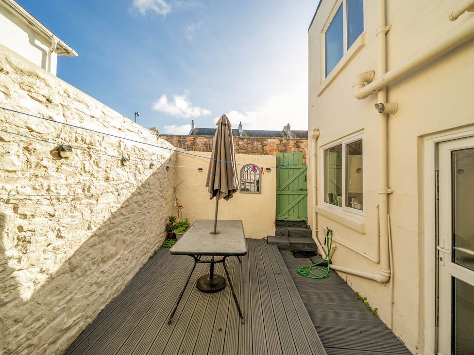 An outdoor space with a table and umbrella at Torquay - House - Sleeps 6 - Pet Friendly, Torquay
