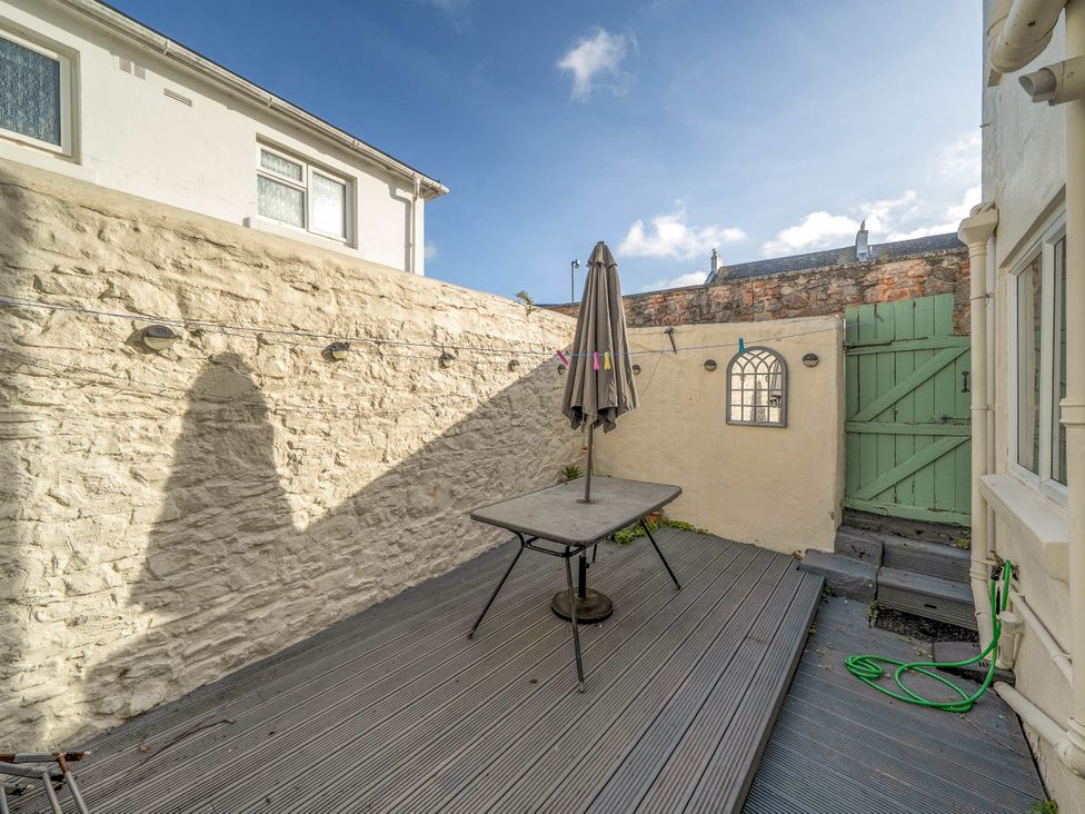 A garden with a table and umbrella at Torquay - House - Sleeps 6 - Pet Friendly, Torquay