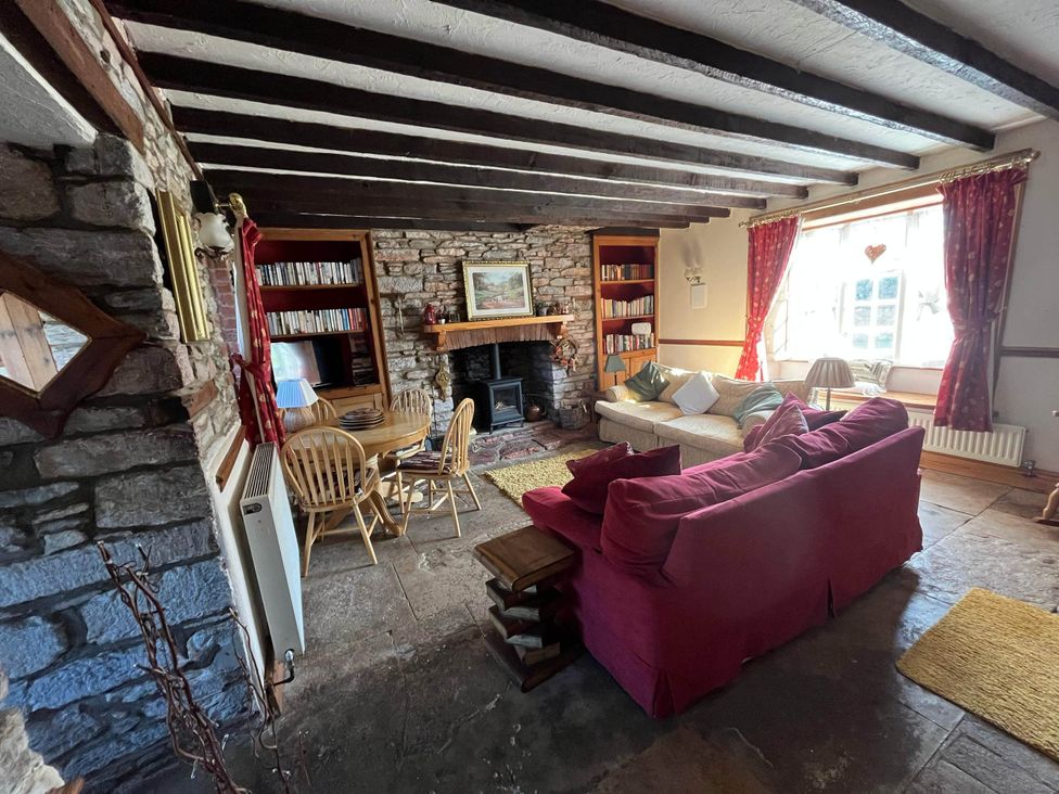 A living room with a sofa and dining table at Quiet cottage on the rural edge of Brixham
