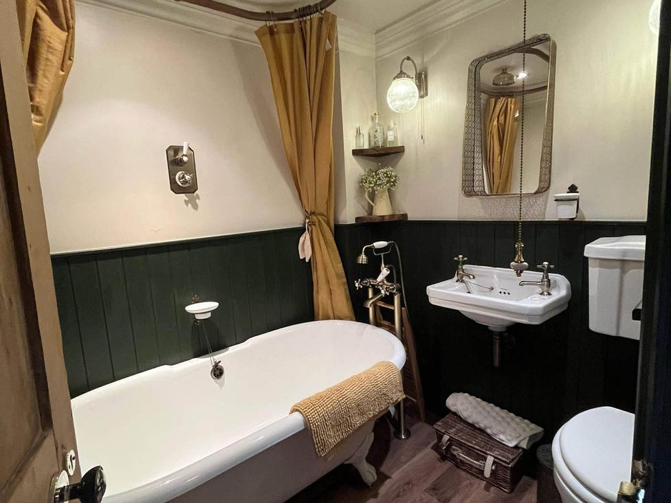 A bathroom with a bathtub, sink and toilet at Quiet cottage on the rural edge of Brixham