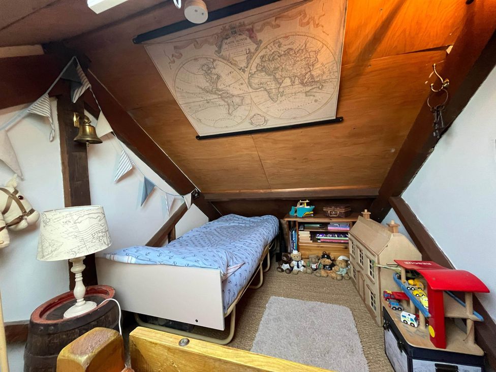 A bedroom with a bed and toys at Quiet cottage on the rural edge of Brixham