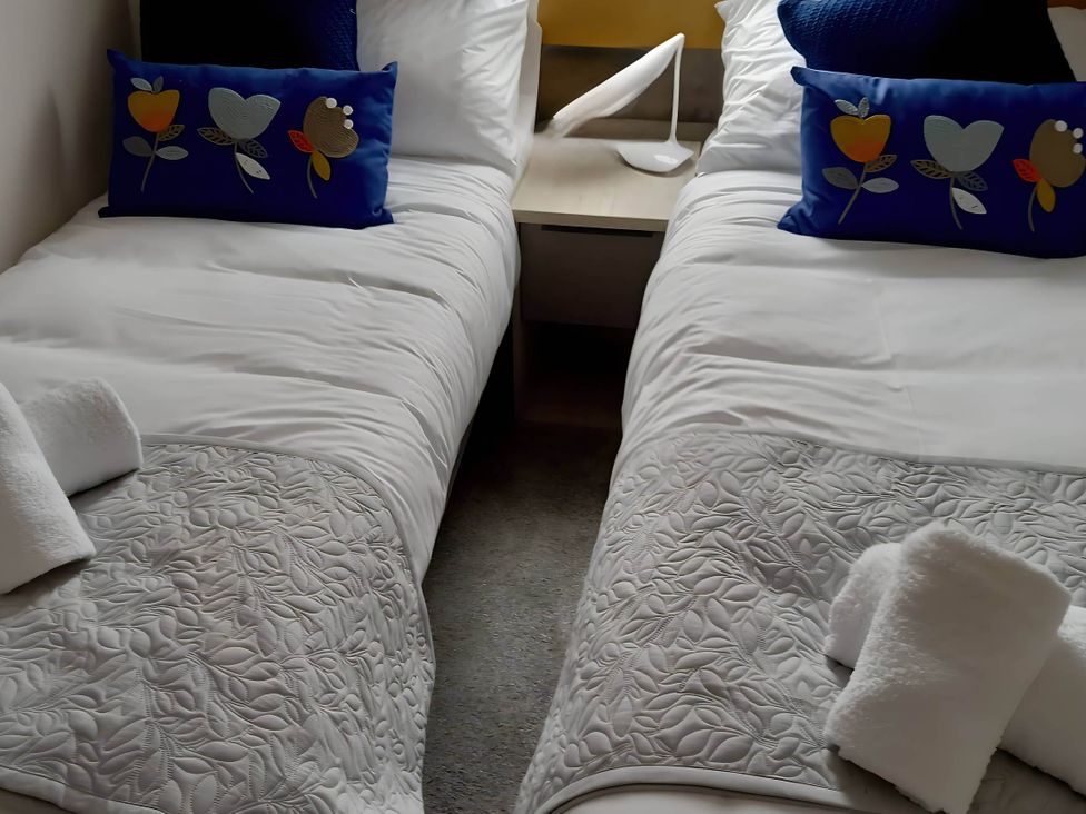 A bedroom with two single beds and a bedside table at Blue water 3 Beverley Bay Static Caravan in Paignton