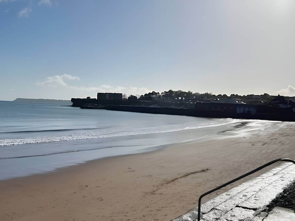 A beach with sand and calm water at Blue water 3 Beverley Bay Static Caravan Paignton