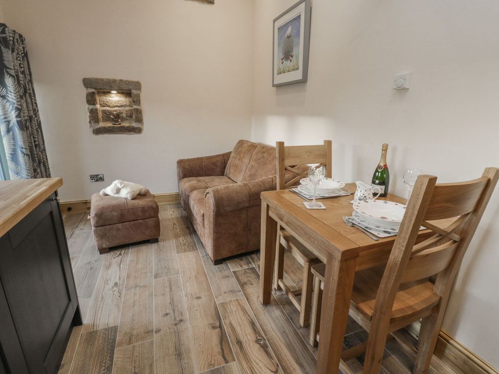 A dining room with a sofa and table setup at Little Esklets in Whitby