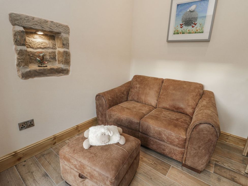 A snug area with a sofa and footstool at Little Esklets in Whitby