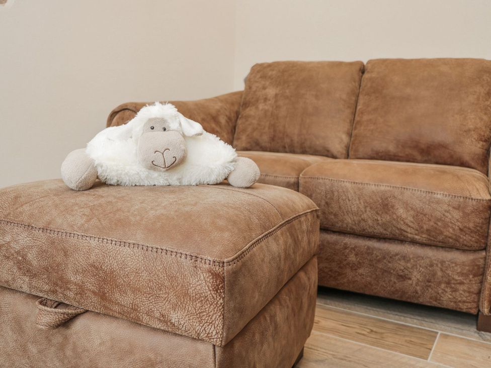 A couch and an ottoman with a stuffed animal at Little Esklets Whitby