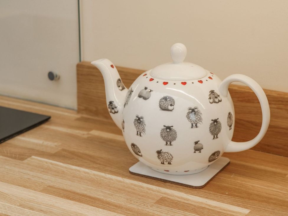 A teapot with sheep designs on a kitchen countertop at Little Esklets in Whitby