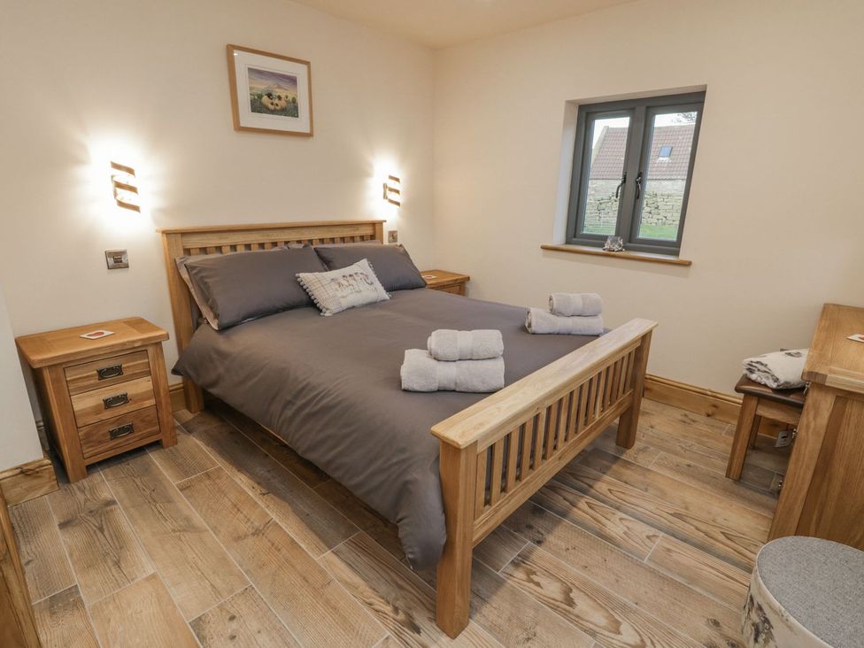 A bedroom with a wooden bed and bedside tables at Little Esklets in Whitby