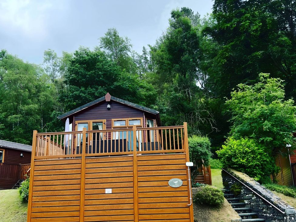 A lodge with decking and steps in a wooded area at 2 Bed Lodge-Sleeps 4-stunning views -Pet Friendly Troutbeck