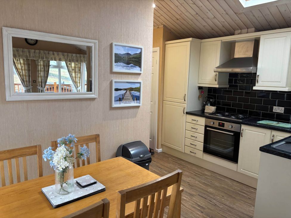 A kitchen with a table and chairs at 2 Bed Lodge-Sleeps 4-stunning views -Pet Friendly in Troutbeck