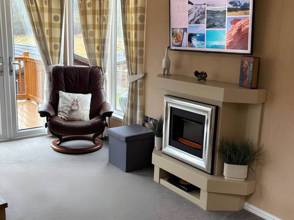 A living room with an armchair and TV at 2 Bed Lodge-Sleeps 4-stunning views -Pet Friendly, Troutbeck