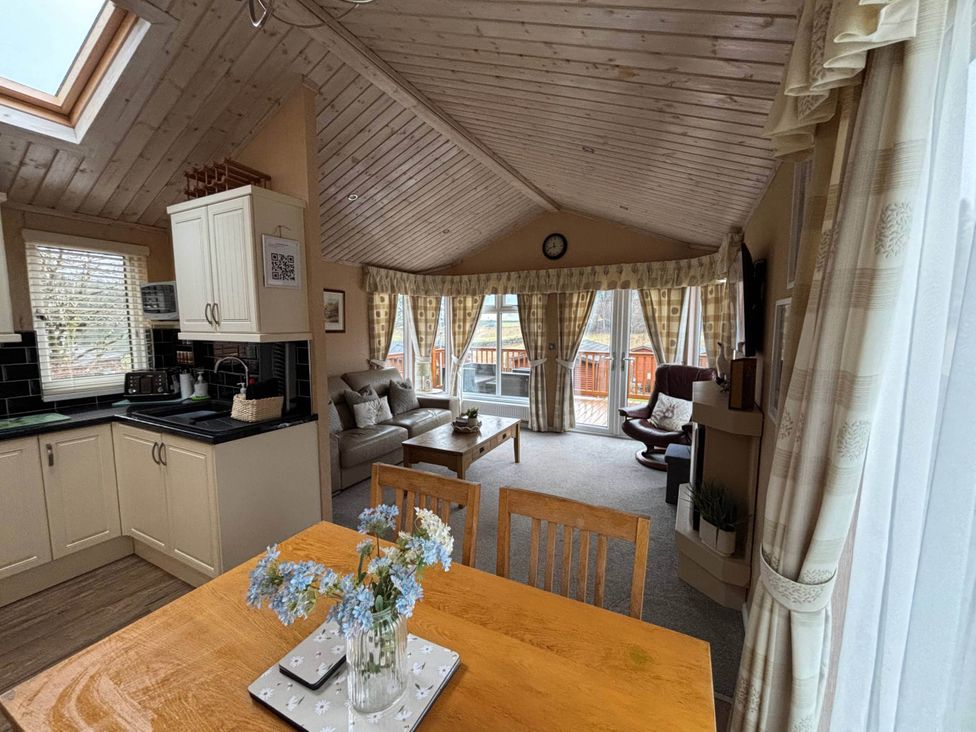 A living room with kitchen area and large windows at 2 Bed Lodge-Sleeps 4-stunning views -Pet Friendly in Troutbeck