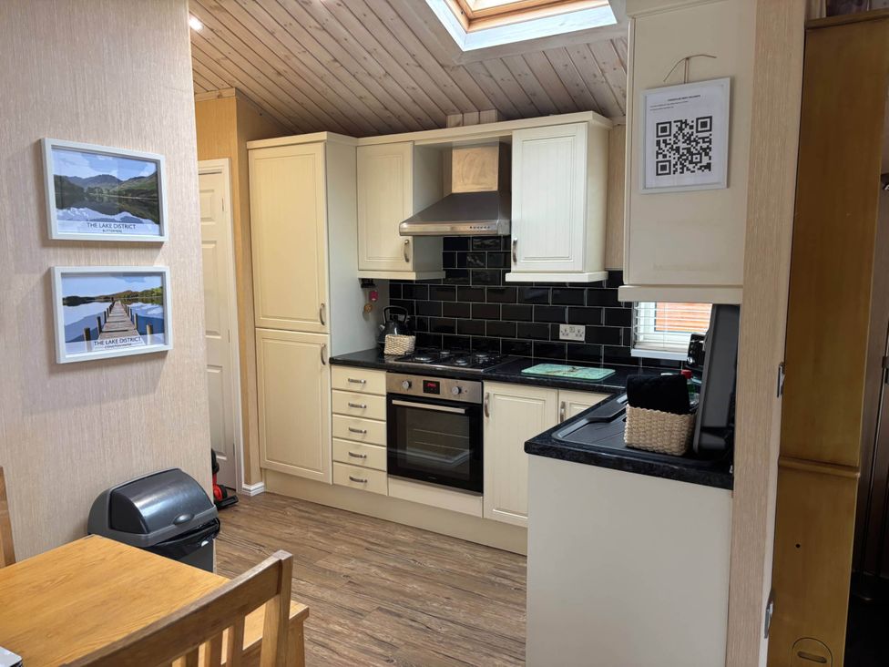 A kitchen with cabinets, stove, and countertop at 2 Bed Lodge-Sleeps 4-stunning views -Pet Friendly, Troutbeck