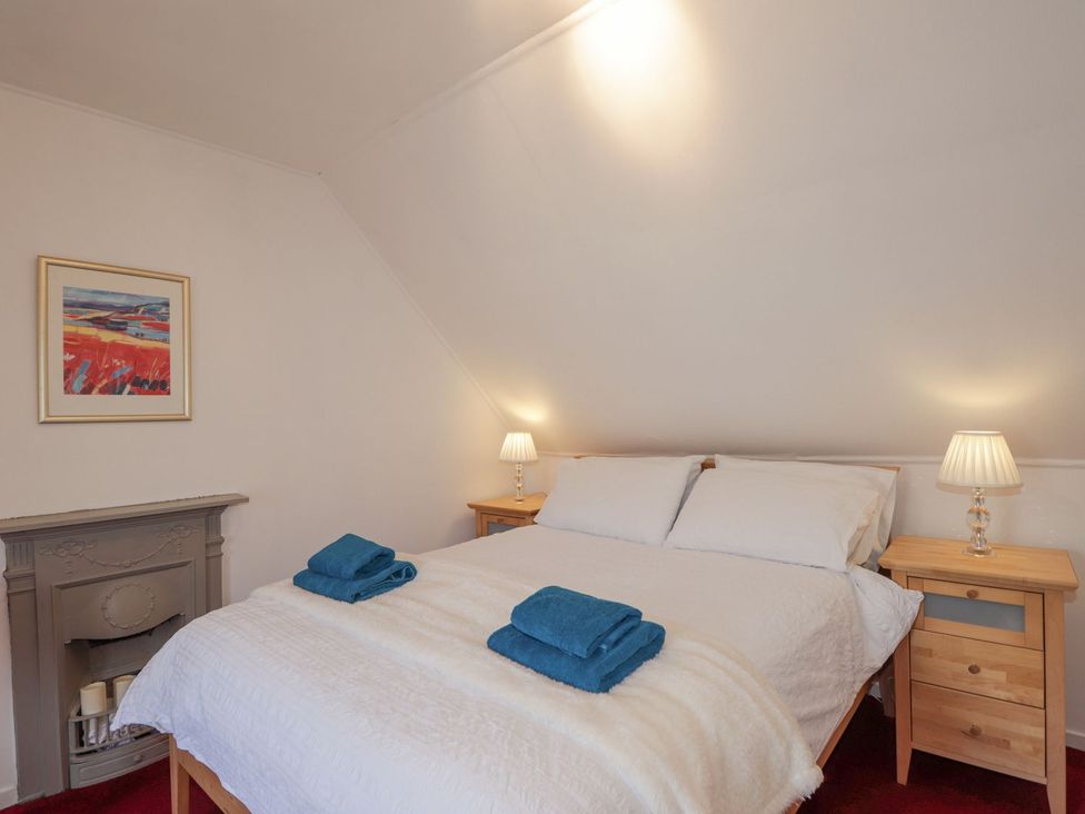 A bedroom with a bed, bedside tables, and lamps at Tigh a Phailean in Kyle