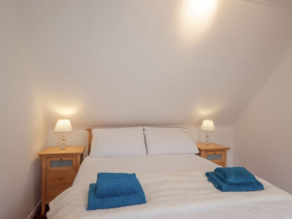 A bedroom with a bed and nightstands at Tigh a Phailean in Kyle