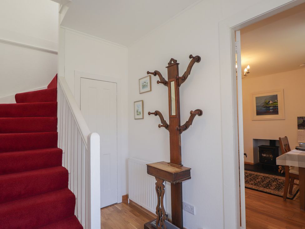 A hallway with stairs and a coat rack at Tigh a Phailean Letterfearn