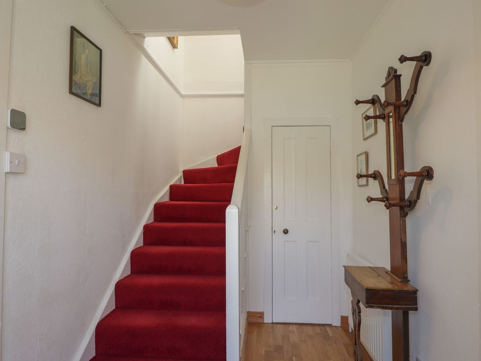 A hallway with stairs and a coat rack at Tigh a Phailean in Letterfearn