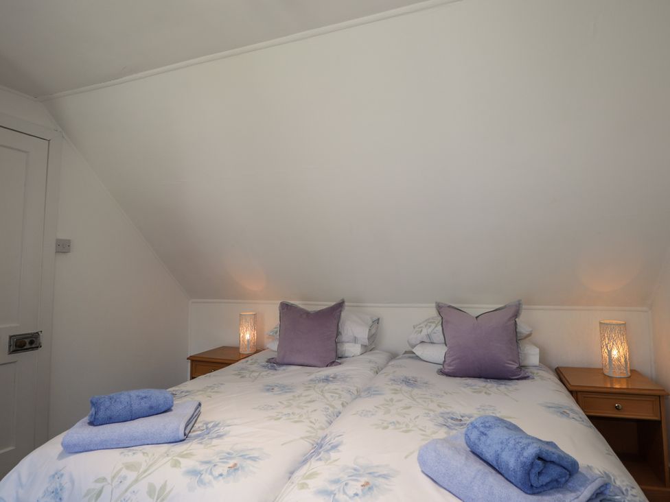 A bedroom with two beds and a nightstand at Tigh a Phailean in Letterfearn