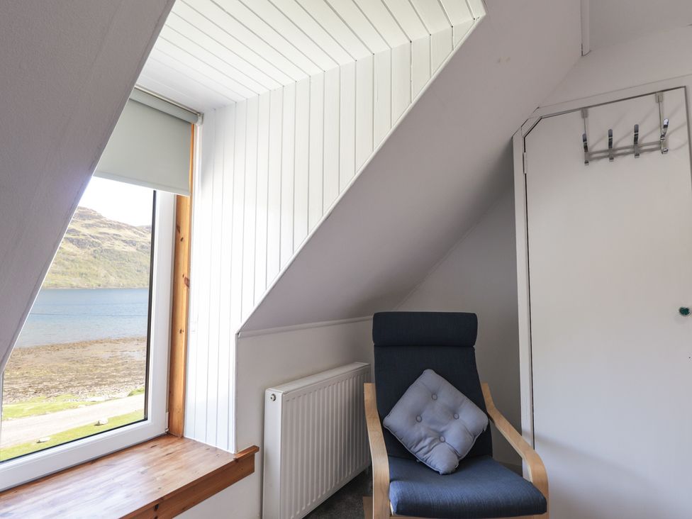 A room with a chair and window at Tigh a Phailean Letterfearn