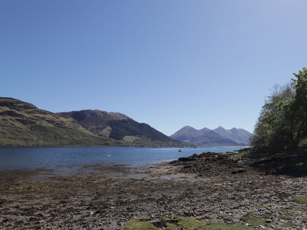 A lakeside view with mountains and trees at Tigh a Phailean in Letterfearn