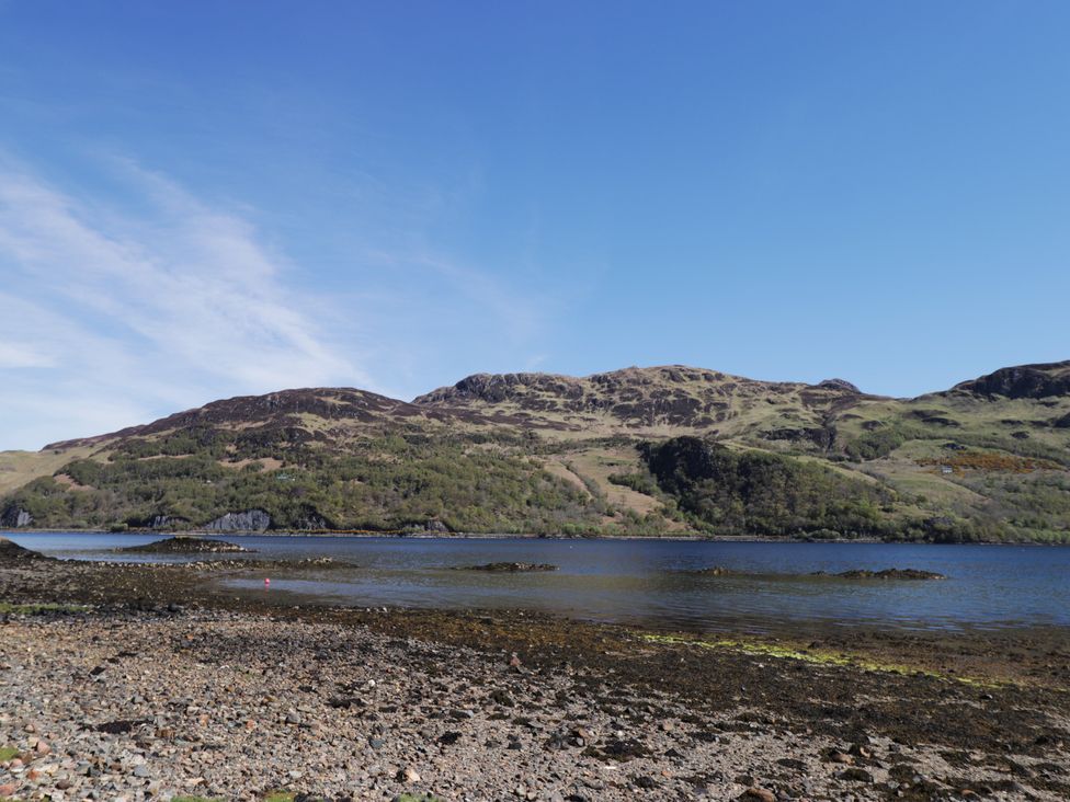 A shoreline with mountains and water at Tigh a Phailean in Letterfearn