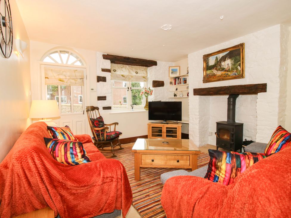 A living room with a sofa and television at Stone Cottage in Church Stretton