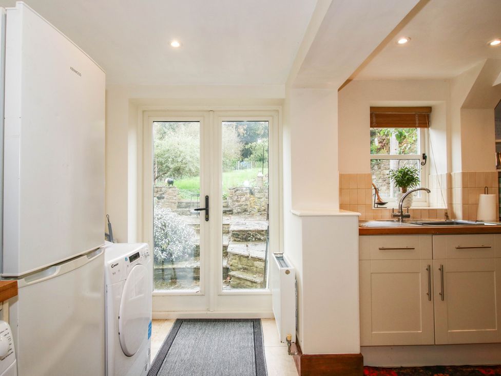 A kitchen with appliances and an entrance door to the outside at Stone Cottage in Church Stretton