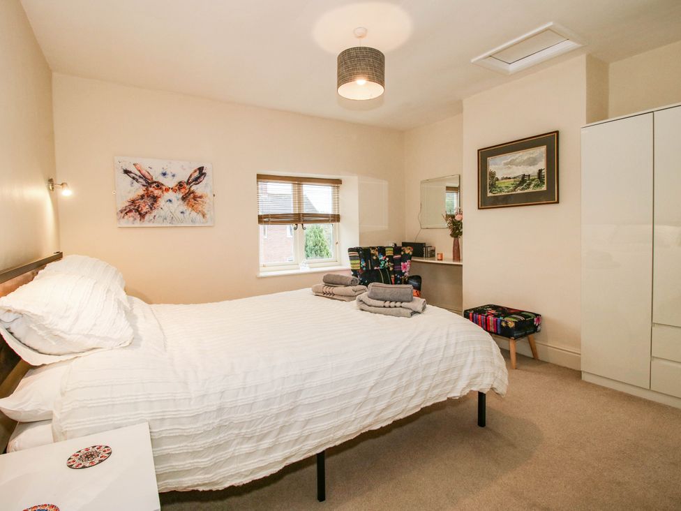 A bedroom with a bed and a desk at Stone Cottage Church Stretton
