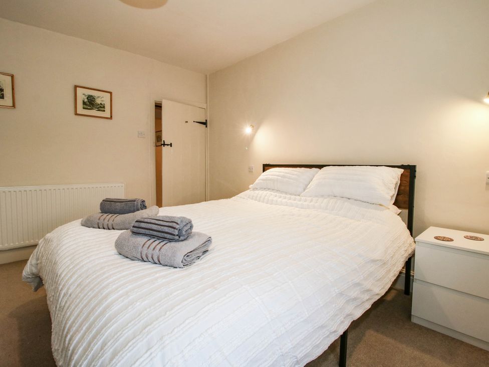 A bedroom with a bed and towels at Stone Cottage in Church Stretton