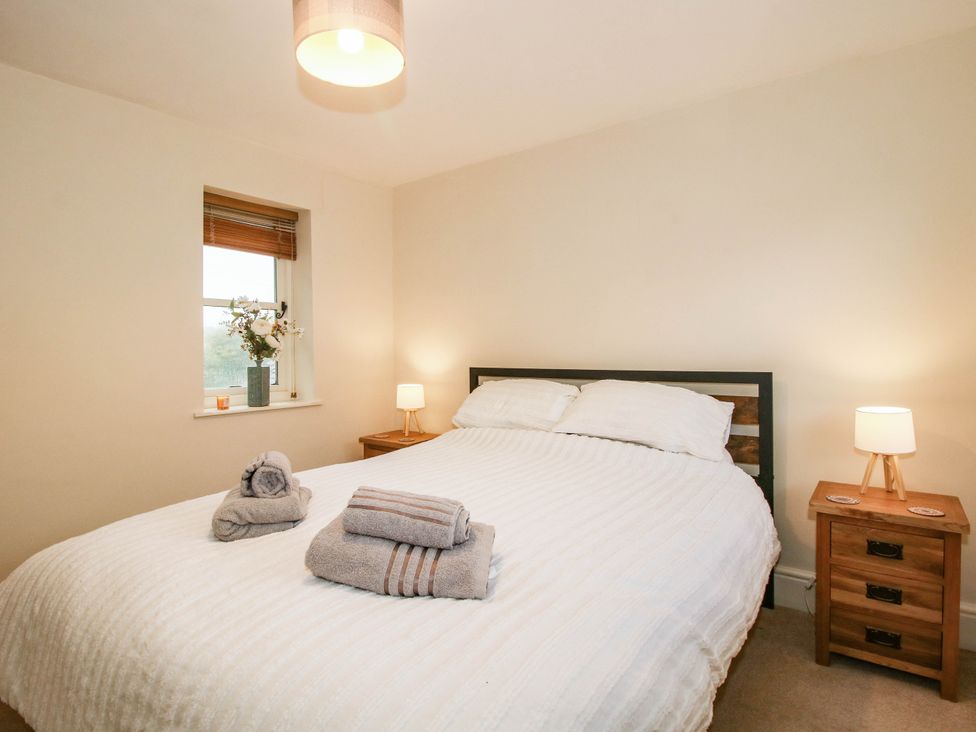 A bedroom with a bed and bedside table at Stone Cottage in Church Stretton