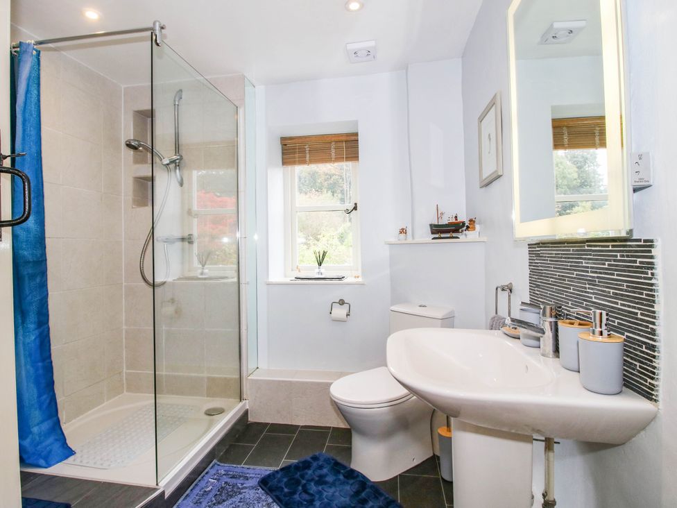 A bathroom with a shower, toilet, and sink at Stone Cottage in Church Stretton