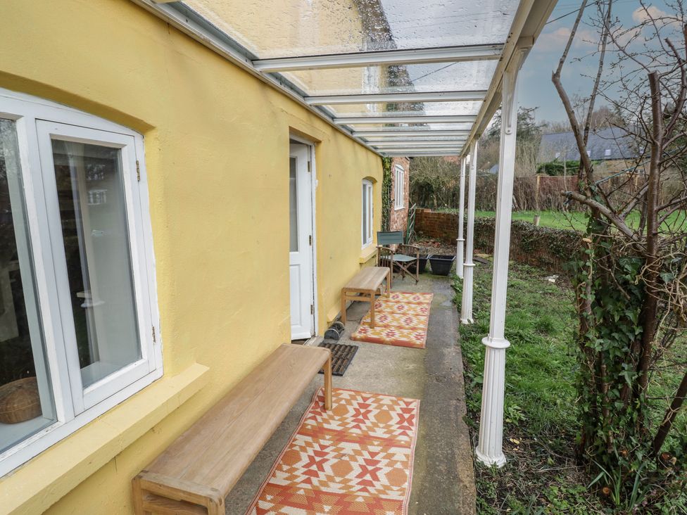 An outdoor area with benches and a canopy at Ambercote in Priors Marston near Southam