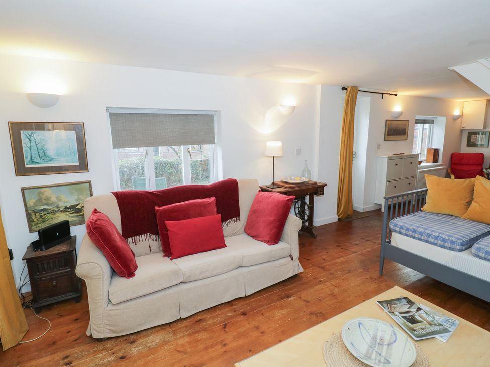 A living room with a sofa and paintings at Ambercote in Priors Marston near Southam