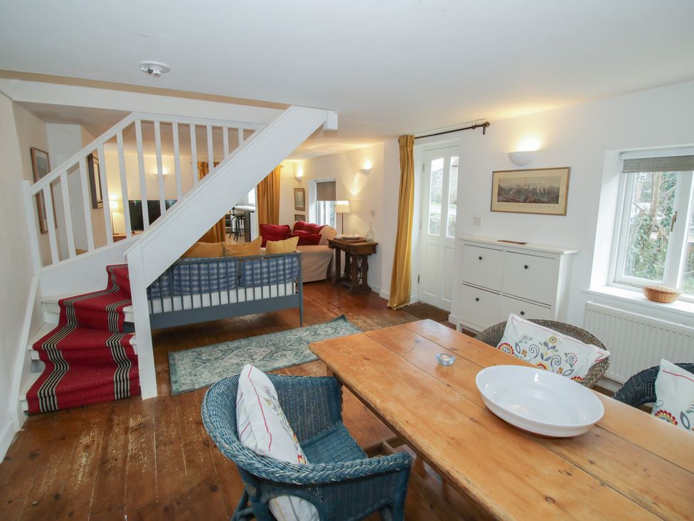 A living room with a dining area and staircase at Ambercote in Priors Marston near Southam