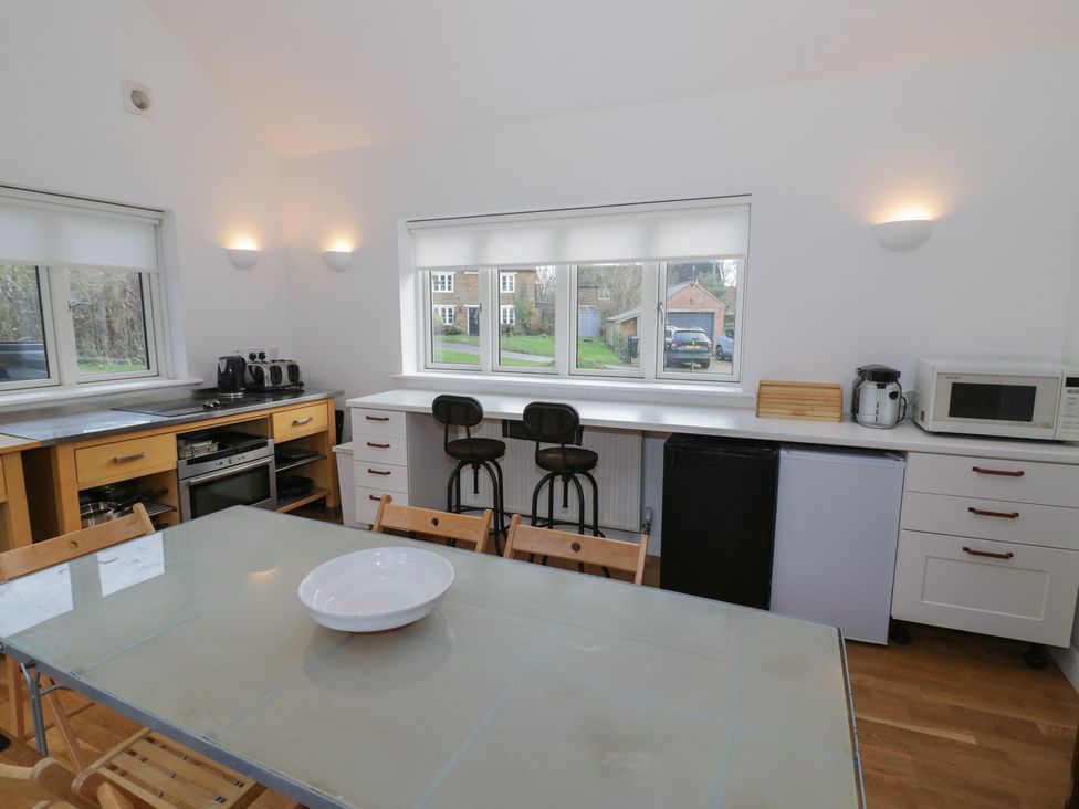 A kitchen with appliances and dining furniture at Ambercote Priors Marston near Southam
